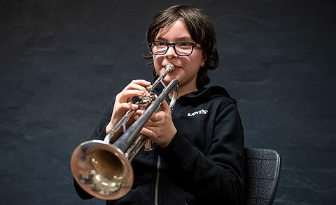 Billedet viser en ung elev der spiller Trompet. 