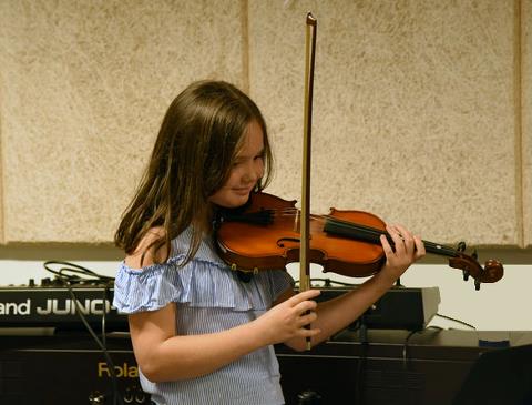 Billedet viser en ung elev der spiller Violin - Suzuki undervisning. 
